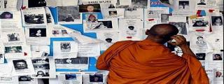 Monk looking at Missing People Notice Tsunami
